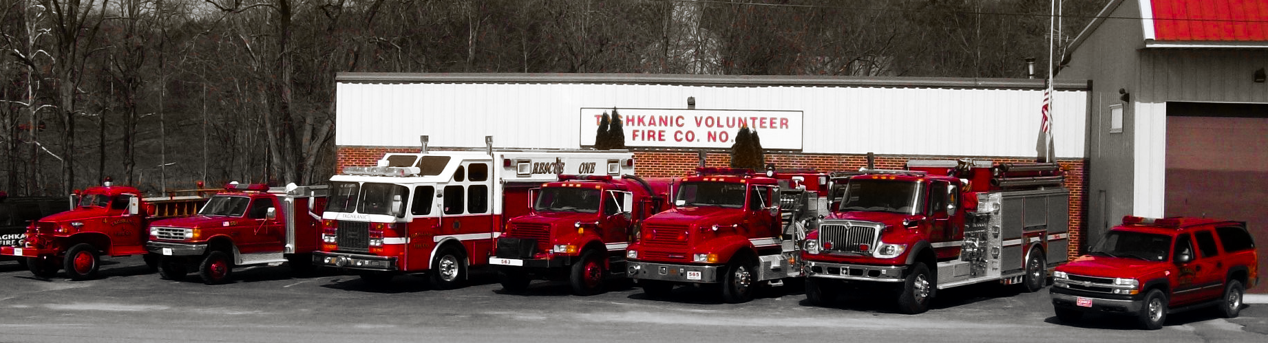Formal photo of the Taghkanic Fire Station #1 with the apparatus of the Company lined up in a row in front of the building.